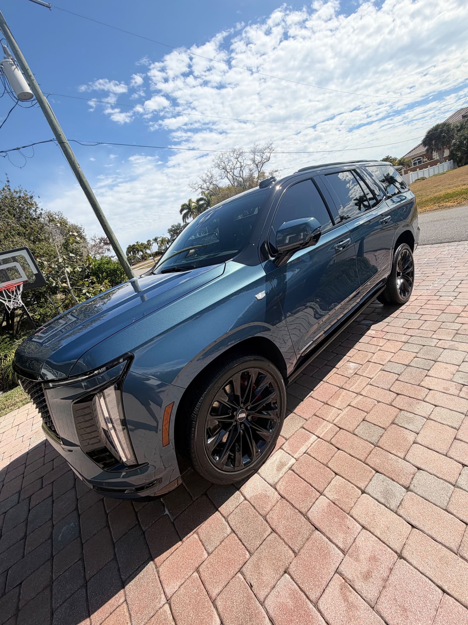 A dark grey SUV freshly detailed on brick pavers